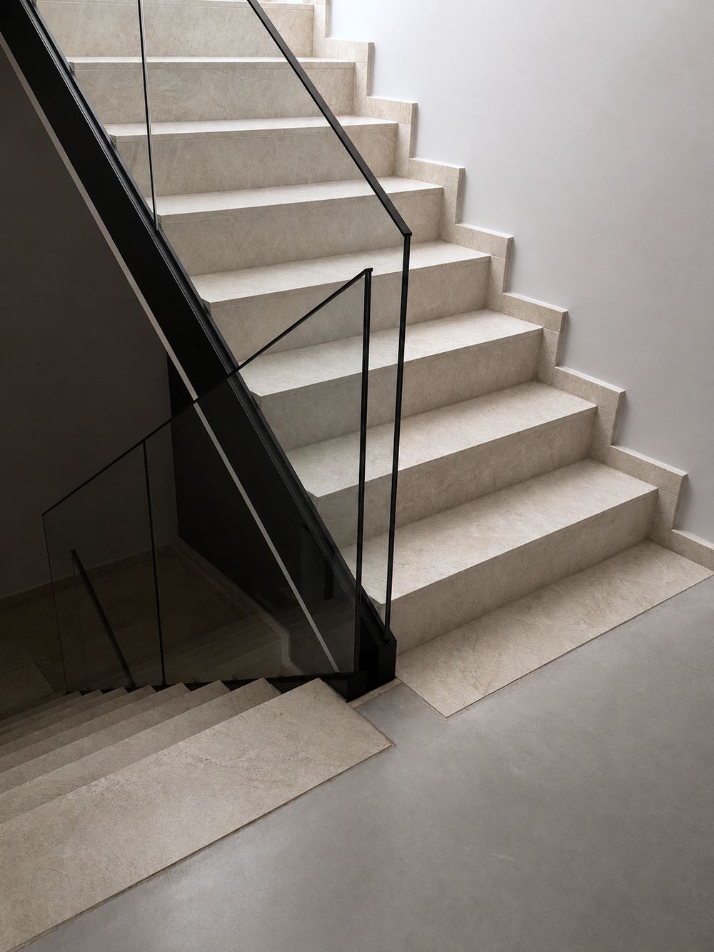 Treppe aus Naturstein mit Glasgeländer zwischen den Ebenen