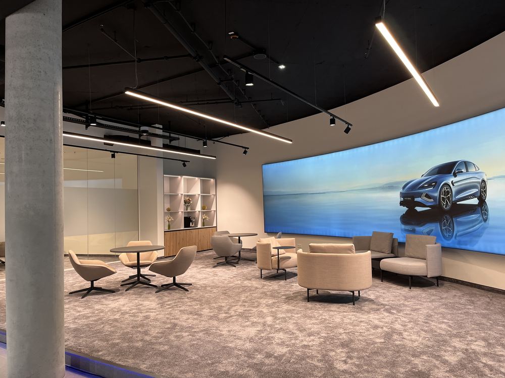 Lounge-Bereich mit Sesseln vor der Medienwand