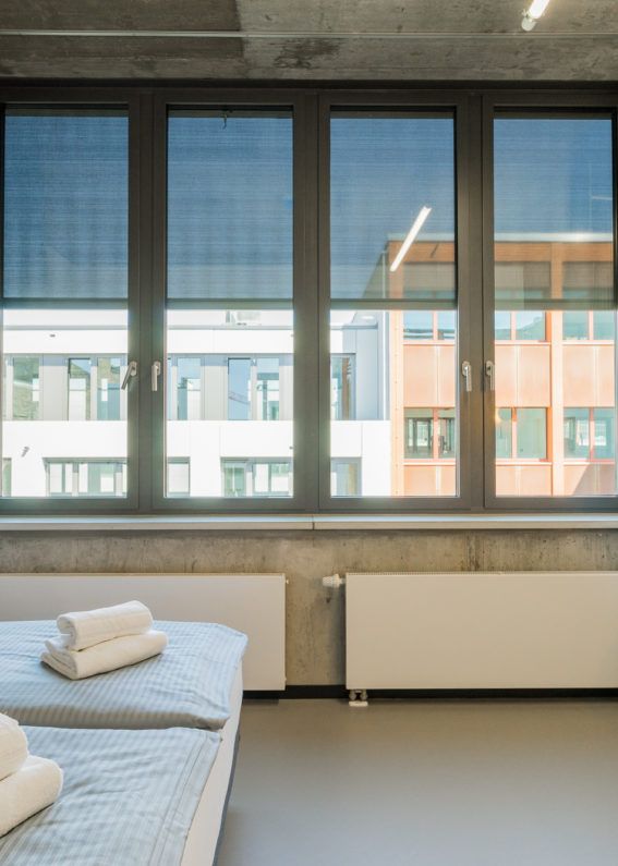 Apartment mit Sichtbetondecke, Arbeitsplatz und bodentiefem Fenster