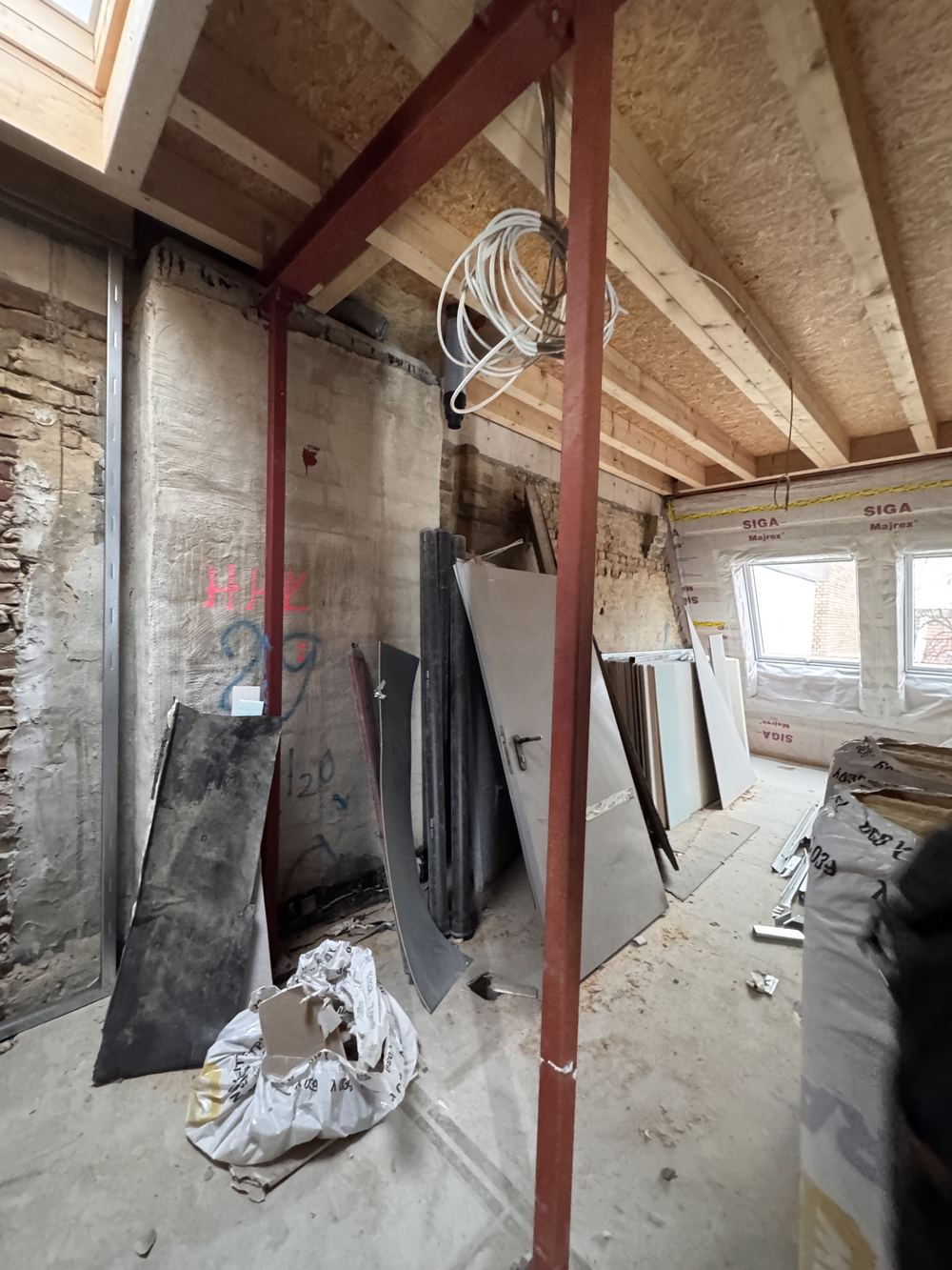 Rote Stahlträger tragen die neue Holzbalkendecke